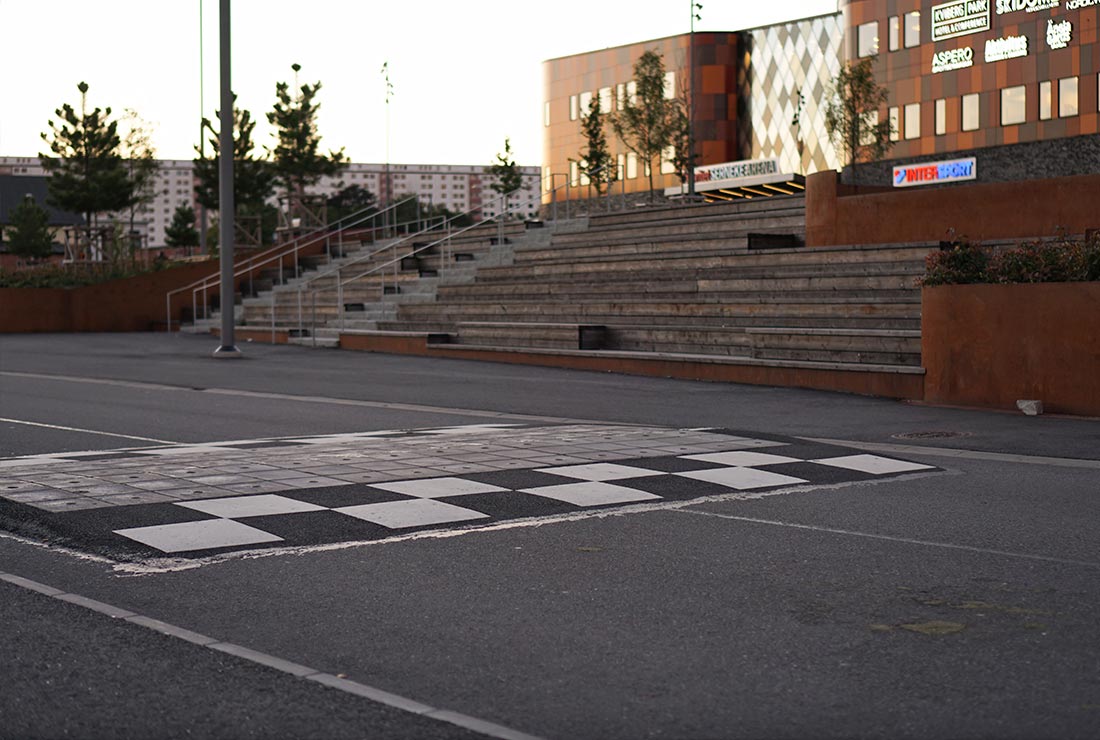 Vägmålning i form av schackrutor på asfalt framför köpcentrum