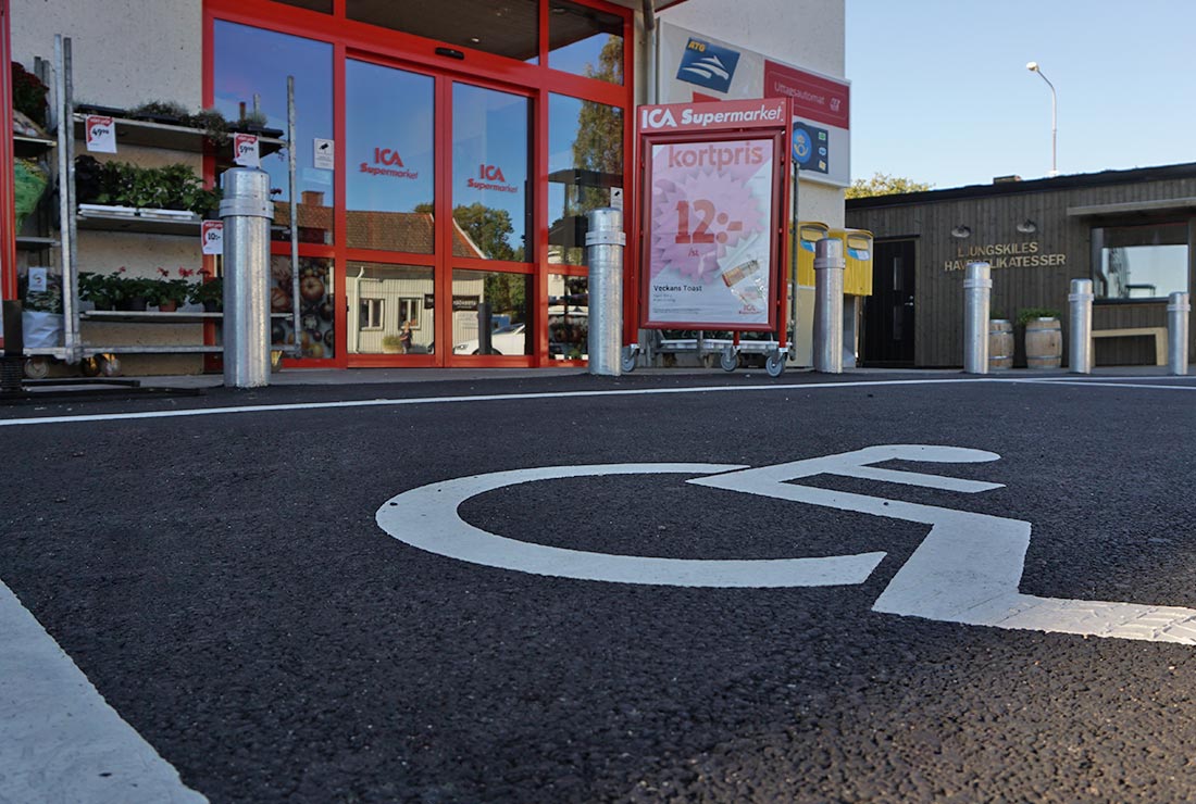 Nymålad linjemarkering för handikapparkering framför en Ica-butik