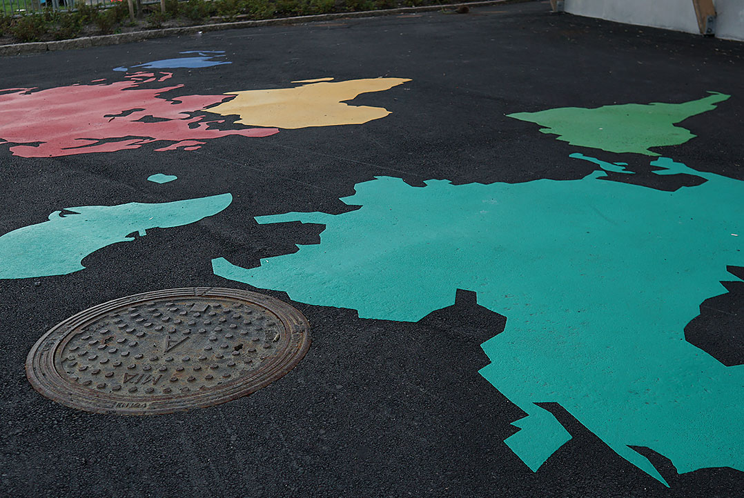 Världsdelar målat i flera olika färger på asfalt